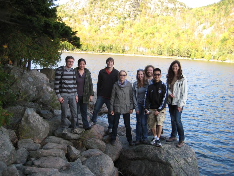 Lab members together beside a mountain lake