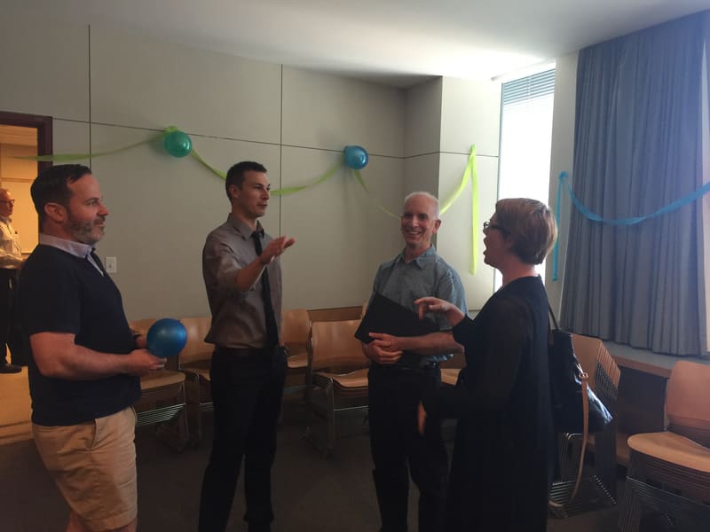 Kevin Harlen talking with guests at his thesis-defense reception