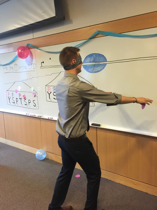 Kevin pointing across the chalkboard during the defense celebration
