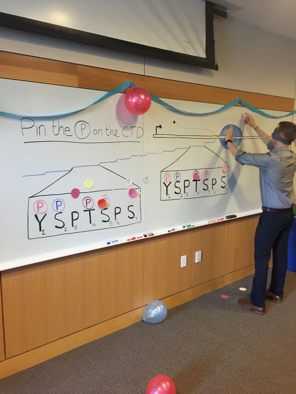 Kevin playing Pin the P on the CTD at a decorated chalkboard