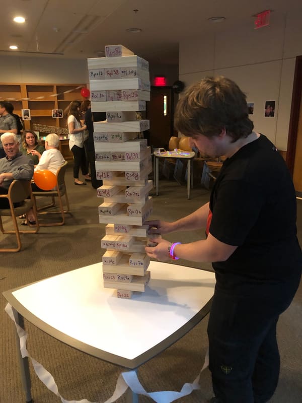 Blake playing a towering game of Jenga during his thesis celebration
