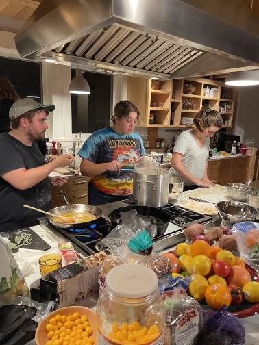 Lab members cooking together in the farmhouse kitchen