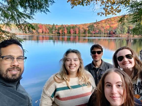 Five lab members taking a selfie beside an autumn pond