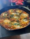 A shakshuka-style retreat meal in a cast-iron pan
