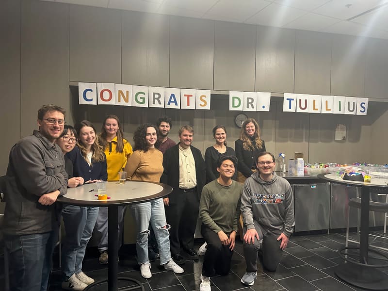 Tommy Tullius surrounded by lab members after his thesis defense