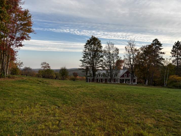 The farmhouse surrounded by early autumn trees